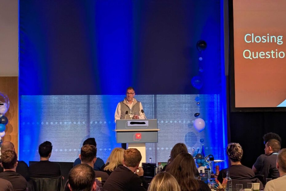 Bram Weerts speaking on stage during the closing questions at a technology customer event.